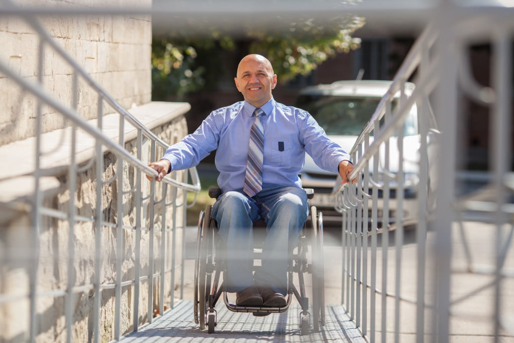 A man in a wheelchair on a ramp going to work