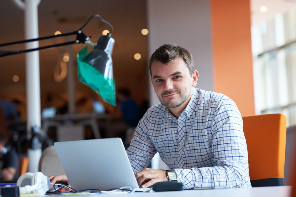 entrepreneur using his laptop smiling
