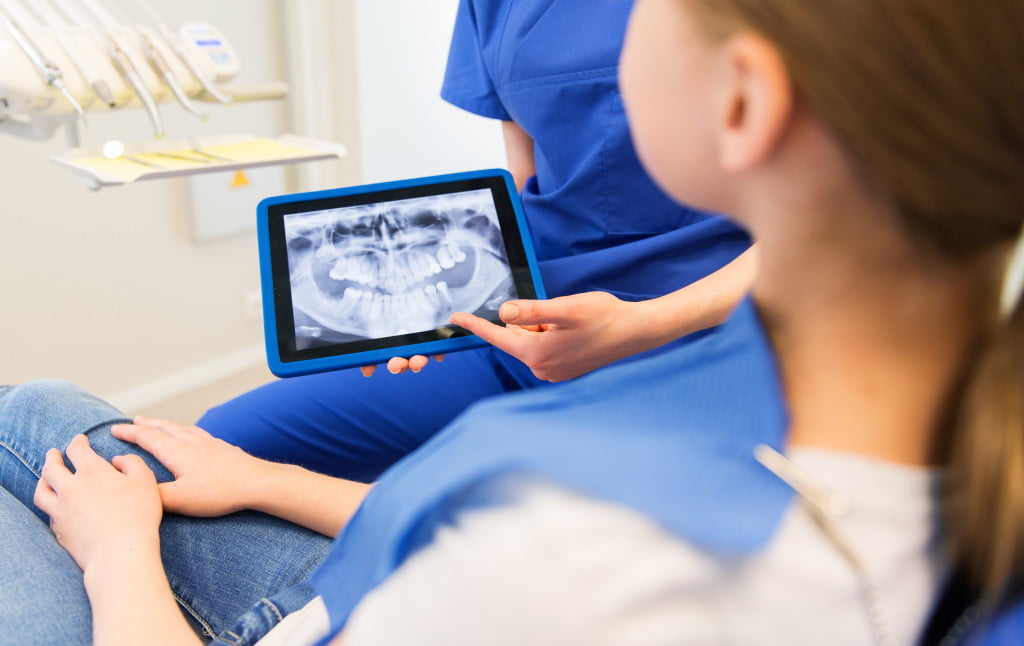 dentist holding a digital image of teeth